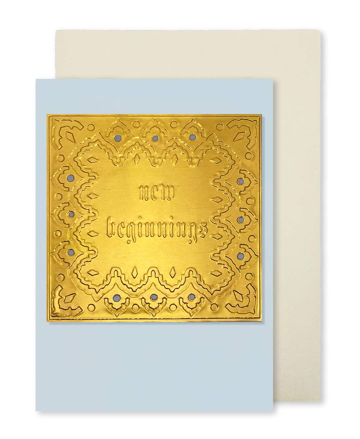 A greeting card by fabler's Press with a raised text design "New Beginnings" with and ornate border on a muted blue card stock, shown with a plain off-white envelope behind it on a white background.