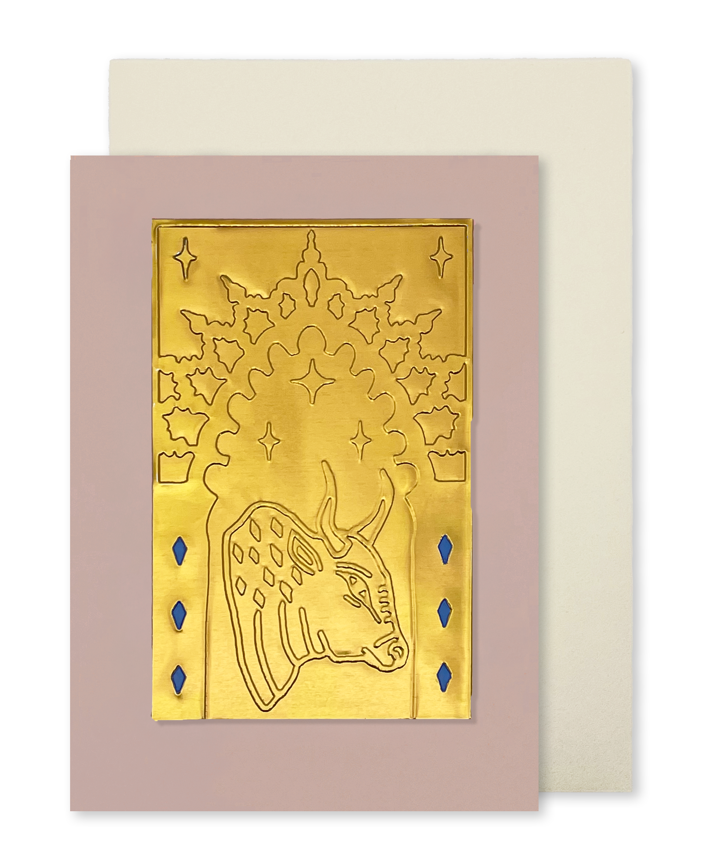 A greeting card with a dusty pink border and a gold foil illustration of a bull under an arch, shown with a cream envelope behind it on a white background.