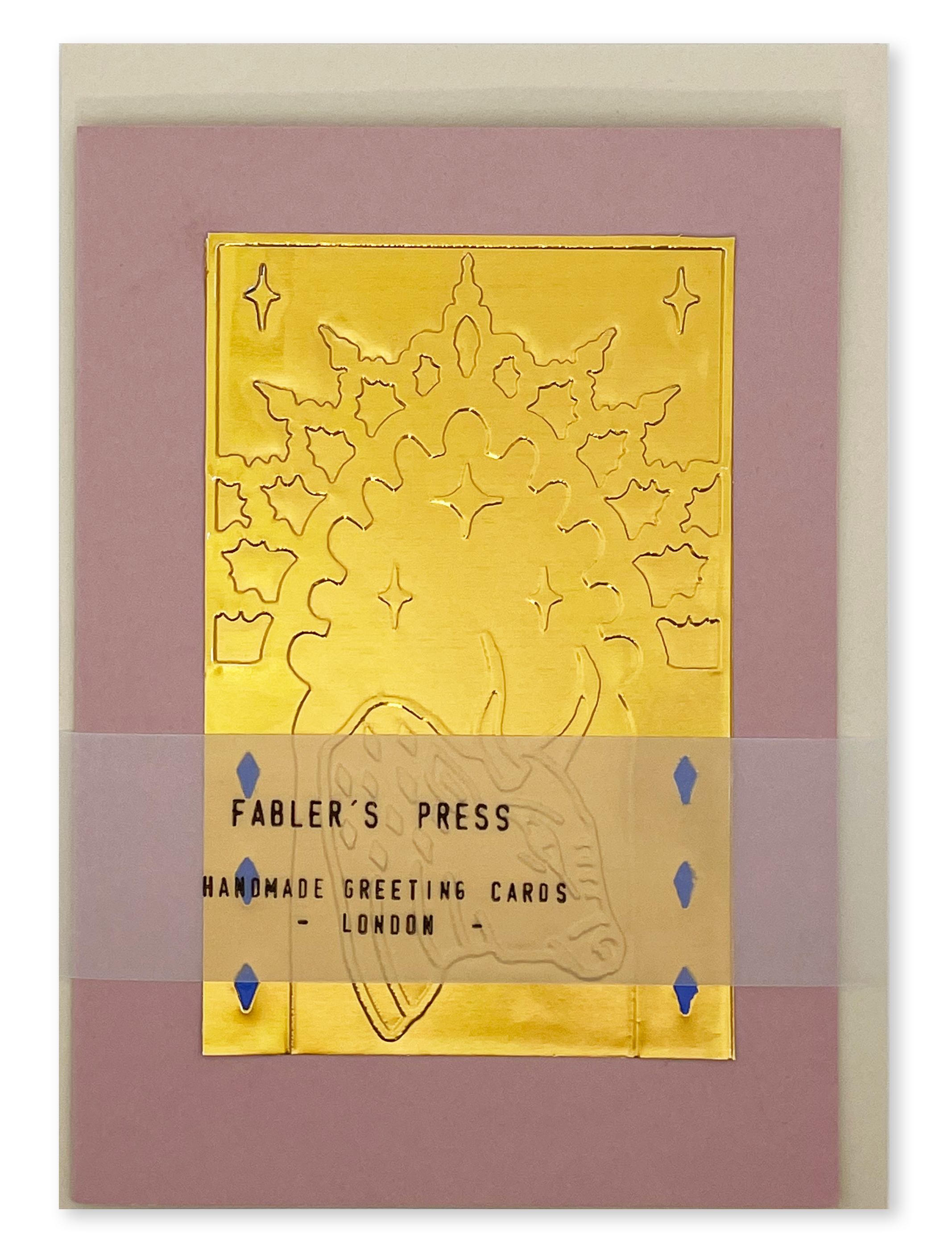 A handmade greeting card from Fabler's Press with a metallic gold foil bull design on a dusty pink card, shown with a belly band packaging and envelope behind.