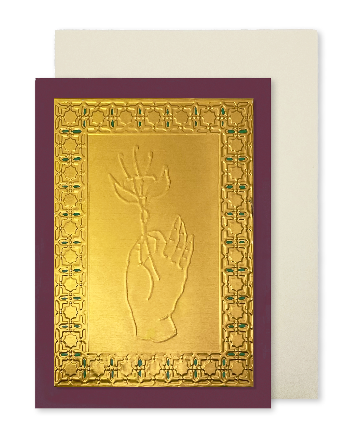 A gold-toned greeting card with a raised hand holding a flower motif, surrounded by an ornate patterned border, set against a deep burgundy background. A cream-coloured envelope is positioned behind the card.