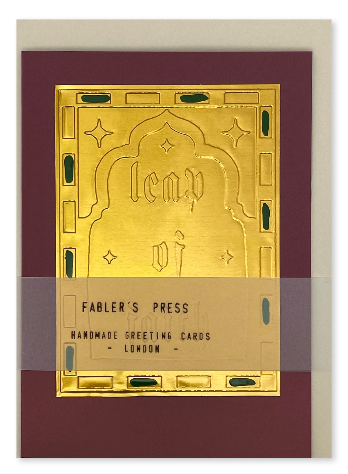 A handmade greeting card from Fabler's Press featuring an ornate gold foil arch design with the words 'Leap Of Faith' in gothic lettering, set against a deep burgundy background with a light cream envelope behind it.